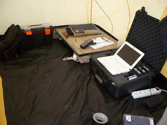 P1030637.JPG - Le centre de communication avec ordinateur relié au téléphone iridium. Les batteries sont connectées au tapis solaire situé à l'extérieur. Sous le téléphone, le carnet d'expédition avec les listes détaillées de l'ensemble du matériel de l'expédition.